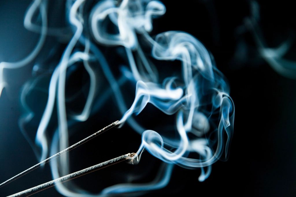 Blue smoke curling against a dark background